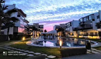 a large swimming pool in front of some buildings at Grand Apartement a Blanca Beach Sidi Rehal in Sidi Rahal