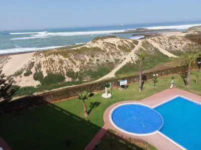 an overhead view of a swimming pool next to the beach at Appartement au bord de l'eau in Mohammedia