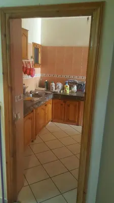 a kitchen with wooden cabinets and a tile floor at Mohamedia in Mohammedia