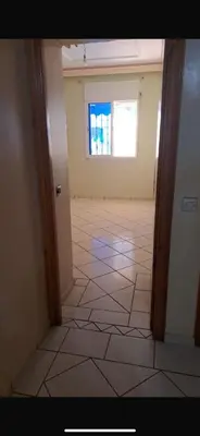 an empty room with a tile floor and a window at Mohamedia in Mohammedia