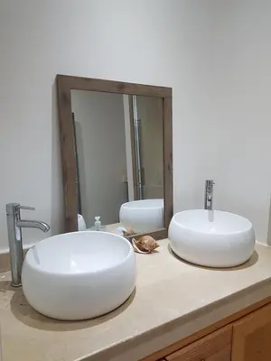 a bathroom with two sinks and a mirror at Les Portes de l'Océan avec piscine uniquement l'été in El Harhoura