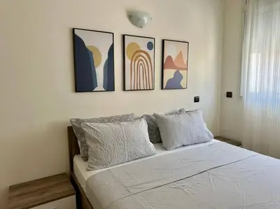 a bedroom with a bed with four pictures on the wall at Rabat, Appartement Neuf en face d'Arribat Center. in Rabat