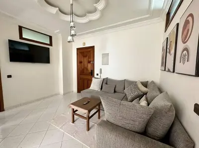 a living room with a couch and a table at Rabat, Appartement Neuf en face d'Arribat Center. in Rabat