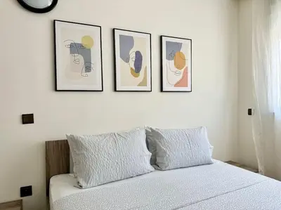 a bedroom with four pictures on the wall above a bed at Rabat, Appartement Neuf en face d'Arribat Center. in Rabat