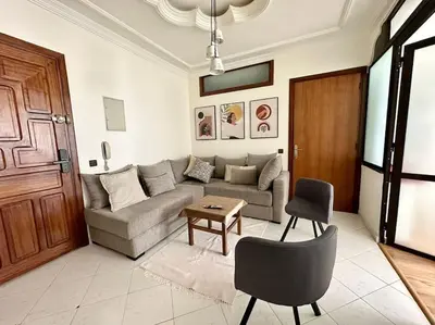 a living room with a couch and a table at Rabat, Appartement Neuf en face d'Arribat Center. in Rabat
