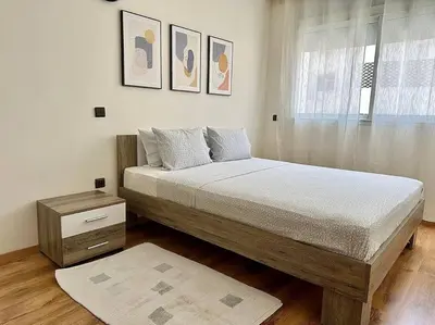 a bedroom with a large bed and a window at Rabat, Appartement Neuf en face d'Arribat Center. in Rabat
