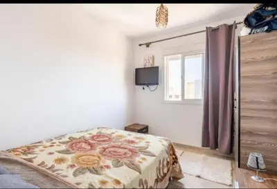 a bedroom with a bed and a window and a television at Havre de Paix chez Lamine in El Harhoura