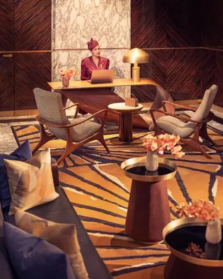 a woman sitting at a table with a laptop in a room at Royal Mansour Casablanca in Casablanca