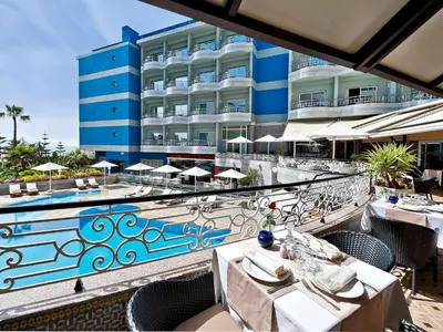 a restaurant with tables and chairs in front of a building at Hôtel Club Val d'Anfa Casablanca Ocean view in Casablanca