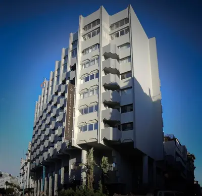 a tall white building with a blue sky in the background at Kenzi Basma in Casablanca