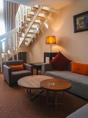 a living room with a couch and a table and stairs at Kenzi Basma in Casablanca