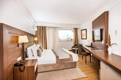 a hotel room with a bed and a desk at Kenzi Basma in Casablanca