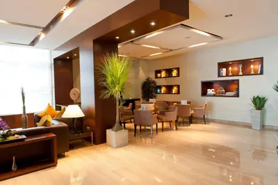 a restaurant with a waiting room with tables and chairs at Barceló Casablanca in Casablanca