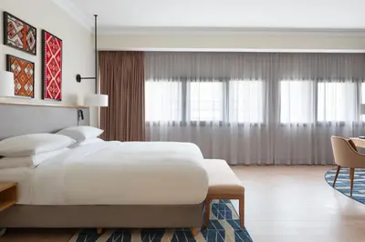 a bedroom with a large white bed and a chair at Casablanca Marriott Hotel in Casablanca