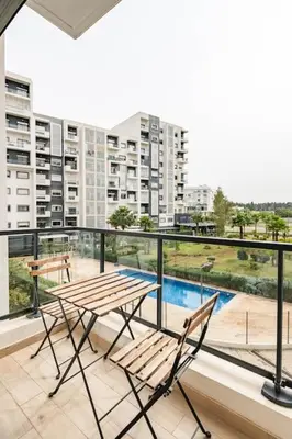 a balcony with a table and chairs on a building at Lovely Appartement Prestigia Hayriad in Rabat