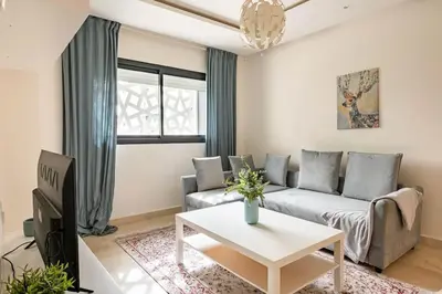 a living room with a couch and a table at Lovely Appartement Prestigia Hayriad in Rabat