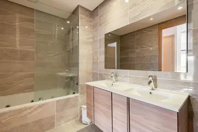 a bathroom with a sink and a mirror and a tub at Lovely Appartement Prestigia Hayriad in Rabat