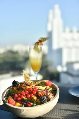 a bowl of fruit and a glass of juice on a table at JM Suites Hotel Eco-Friendly Casablanca in Casablanca