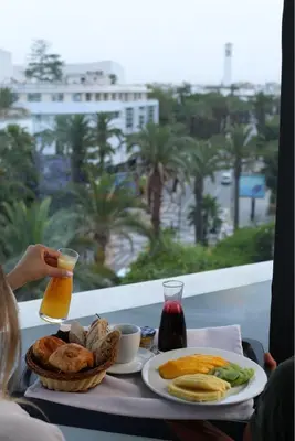 a table with a breakfast of bread and orange juice at JM Suites Hotel Eco-Friendly Casablanca in Casablanca