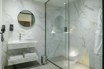 a bathroom with a shower and a sink and a mirror at JM Suites Hotel Eco-Friendly Casablanca in Casablanca
