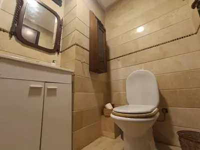 a bathroom with a white toilet and a mirror at Appartement de Charme Avec Vue Sur Mer in Casablanca