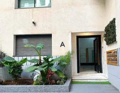 a building with a door and plants in front of it at luxe appartement met zeezicht en zwembad Mohammedia Parc in Mohammedia