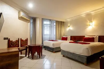 a hotel room with two beds and a table at Hotel Casablanca City Center in Casablanca