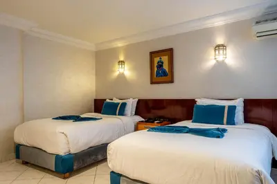a hotel room with two beds with blue pillows at Hotel Casablanca City Center in Casablanca