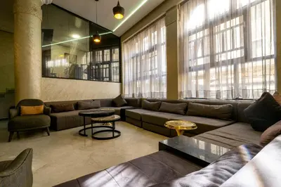 a living room with a couch and tables and windows at Hotel Casablanca City Center in Casablanca
