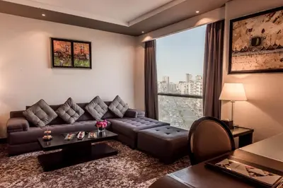 a living room with a couch and a large window at Kenzi Tower Hotel in Casablanca