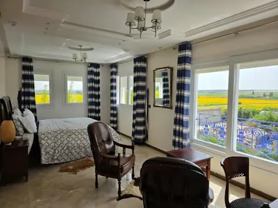 a bedroom with a bed and a room with windows at Instant Saisons - Ferme d'hôtes in Skhirat
