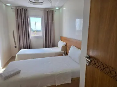 a hotel room with two beds and a window at Instant Saisons - Ferme d'hôtes in Skhirat