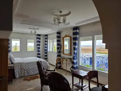 a bedroom with a bed and a table and chairs at Instant Saisons - Ferme d'hôtes in Skhirat