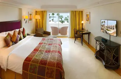a hotel room with a large bed and a desk at L' Amphitrite Palace Beach Resort & Spa in Skhirat