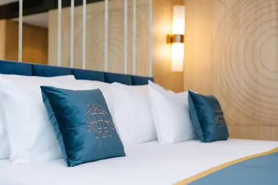 a bed with blue and white pillows on it at Royal Hideaway Casablanca in Casablanca
