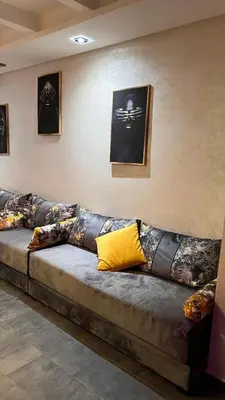 a long couch in a room with pictures on the wall at Résidence Galets Sur Mer in Dar Bouazza