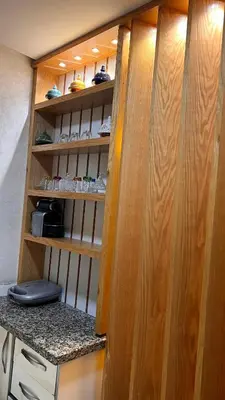 a closet with a wooden door and a counter with shoes at Résidence Galets Sur Mer in Dar Bouazza