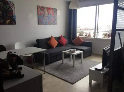 a living room with a couch and a table at Amazing view overlooking the ocean and Hassan 2 in Casablanca