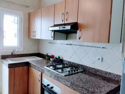 a kitchen with wooden cabinets and a stove top oven at Splendid appartament a 3 Min de la mer et de la mosquée hassan 2 in Casablanca