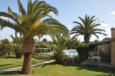 two palm trees in a yard next to a swimming pool at Gite Nadia in Casablanca