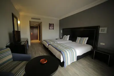 a hotel room with two beds and a couch at Hotel Suisse in Casablanca
