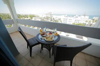 a table with food and drinks on a balcony at Hotel Suisse in Casablanca