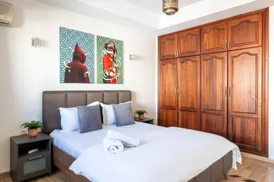 a bedroom with two beds and a large wooden cabinet at Arribat Center Mall- TT Holidays Agdal in Rabat