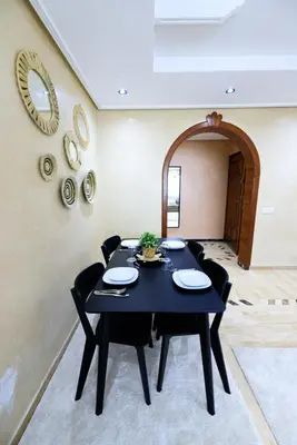 a dining room with a black table and black chairs at Arribat Center Mall- TT Holidays Agdal in Rabat