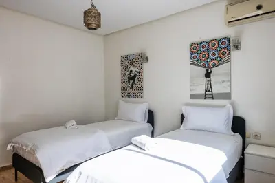 two beds in a room with white walls at Arribat Center Mall- TT Holidays Agdal in Rabat