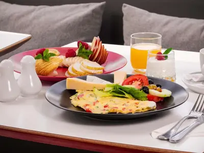 a table with two plates of food and a glass of orange juice at Ibis Casablanca Sidi Maarouf in Casablanca