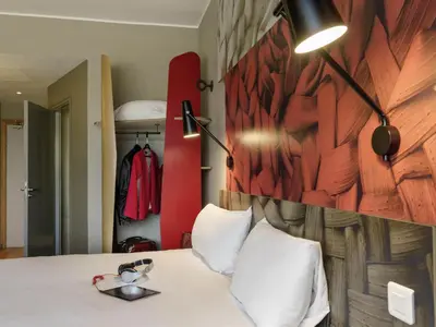 a bedroom with a white bed with a wooden wall at Ibis Casablanca Sidi Maarouf in Casablanca