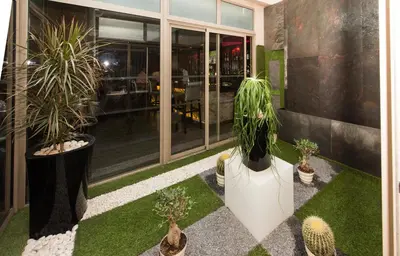 a garden with potted plants and a building at Hotel Toubkal in Casablanca