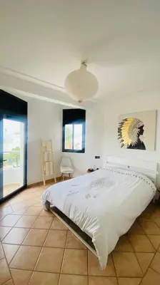 a bedroom with a bed and a painting on the wall at Sunset escape by the sea in Temara