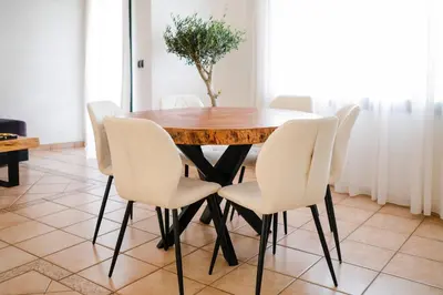a dining room table with white chairs around it at Sunset escape by the sea in Temara